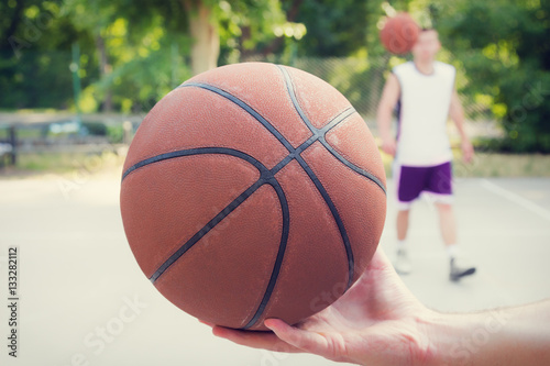 Basketball player holding a ball on the court. © astrosystem
