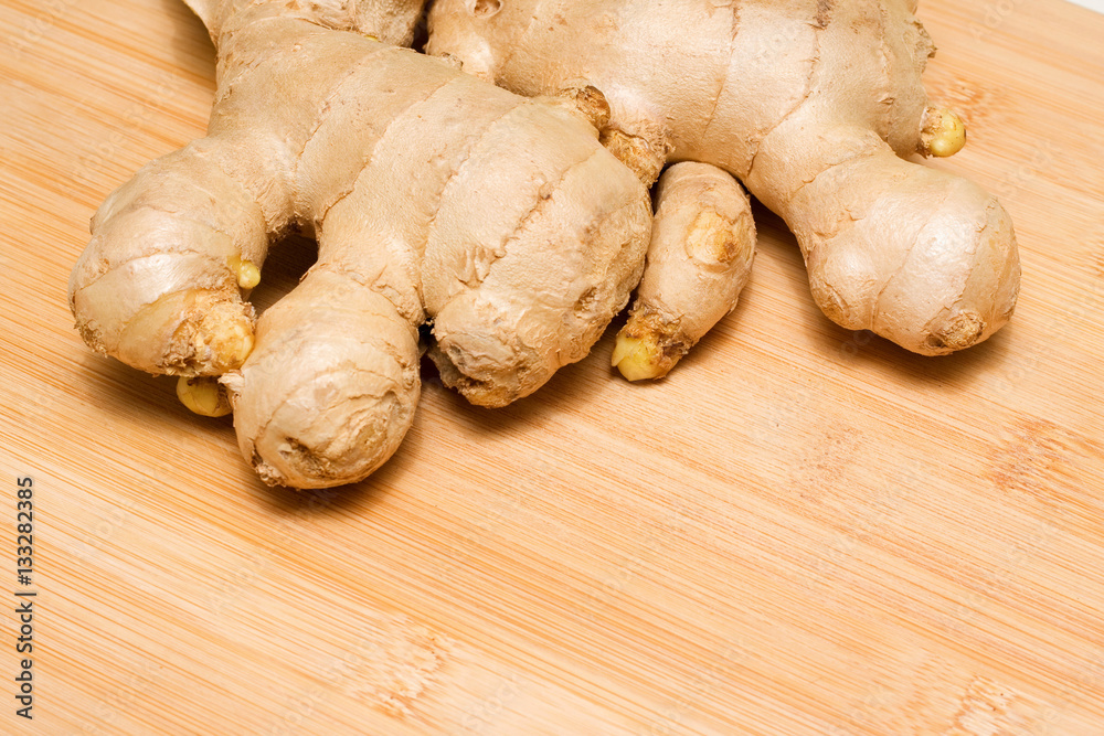 Ginger root on a bamboo chopping block Ginger root on a bamboo chopping block