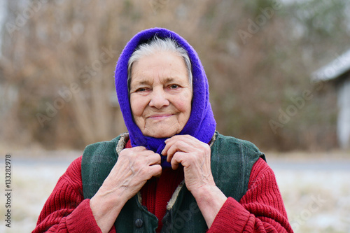 Portrait of smiling old woman in blue headscarf