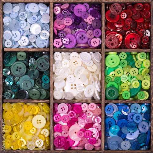 Wooden storage box filled with buttons. photo