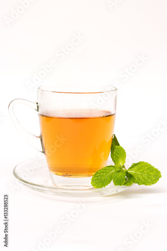Glass cup of breakfast tea with mint leaves isolated on white background