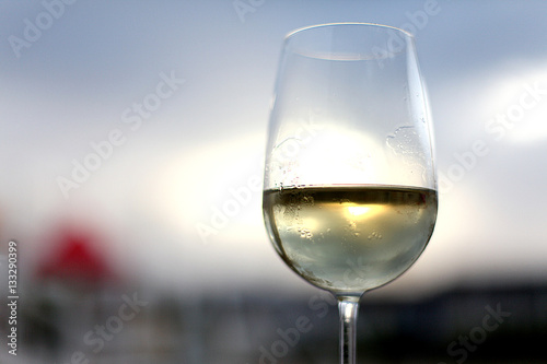 Glass of white wine on the sky background