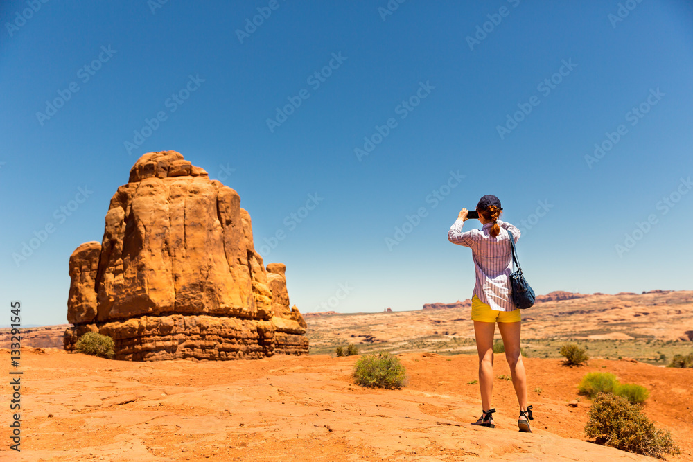 Young woman take pictures at monument valley