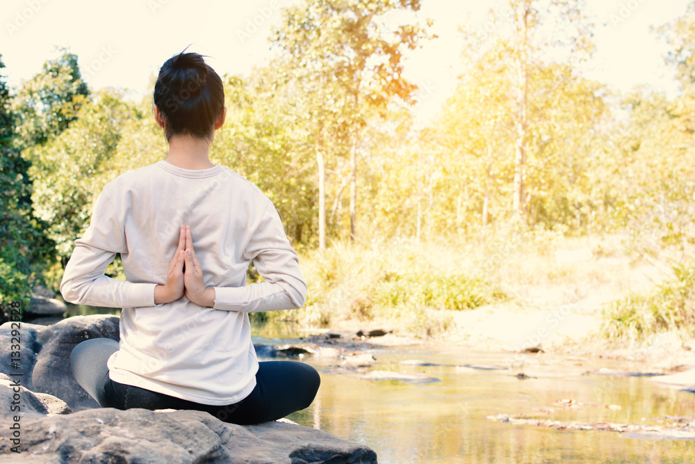 Fototapeta premium Asian women yoga in nature near waterfall relax time