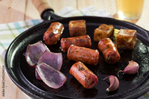 Linguiça artesanal, alho, cebola e queijo coalho na chapa com cerveja photo