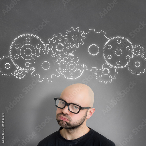 Gear wheel going out of the head of a young attractive bored man