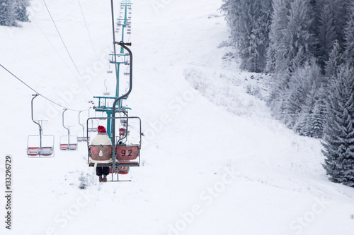Skiers on ski-lift in snow mountains at winter day. 
