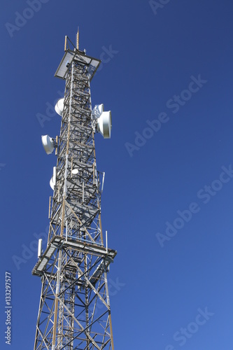 Telecommunications tower in front of a dark blue sky