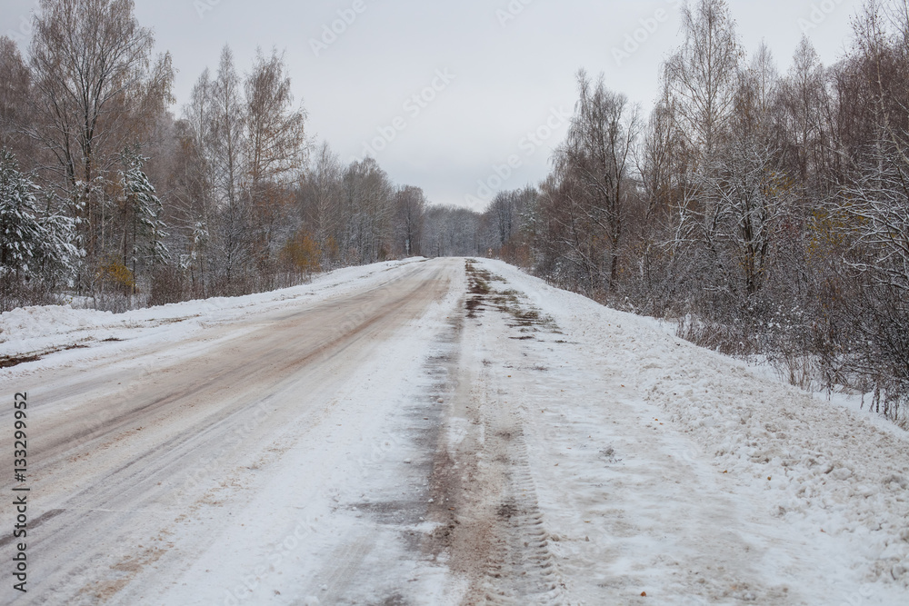 Obraz premium the snow-covered winter road in the wood