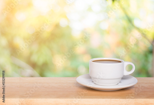 Coffee cup on the wooden table and green bokeh background