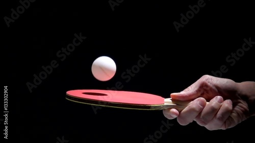 Hand holding table tennis racket and bouncing ping pong ball. Slow motion film clip with sport equipment.
