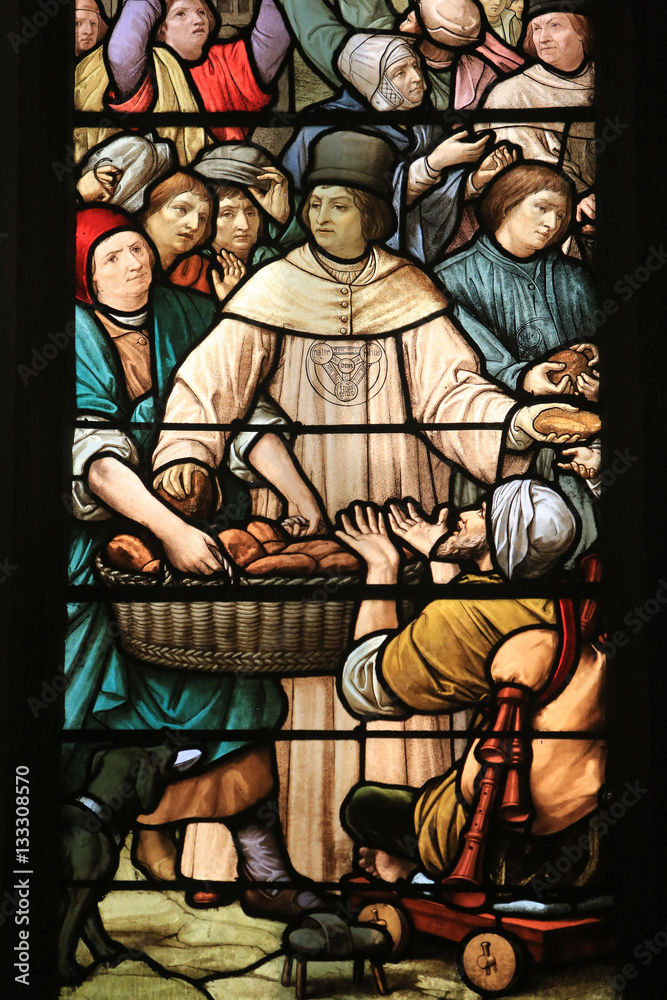 Obraz premium Distribution statutaire des pains aux pauvres par la confrérie. 1894. Vitrail. Eglise Saint-Nizier de Lyon. / Trinity Brothers Helping the Poors. Stained glass windows. Saint-Nizier Church. Lyon.