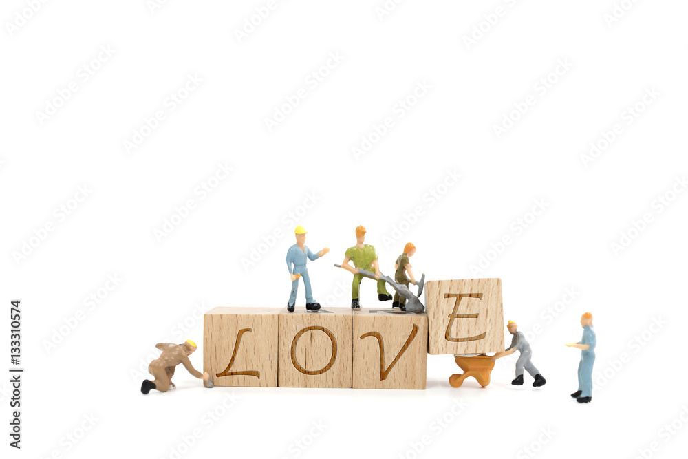 Miniature worker team building word love on white background Miniature worker team building word love on white background