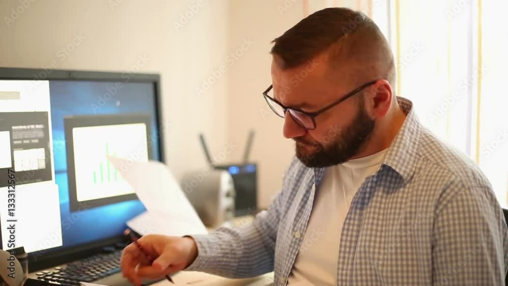 Handsome businessman working from home office doing paper work
Handsome businessman working from home office doing paper work