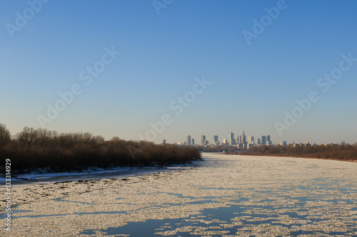 Warsaw skyline with frozen Vistula river in sunlight