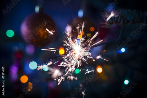sparkler on christmas tree on colorful blurry background
