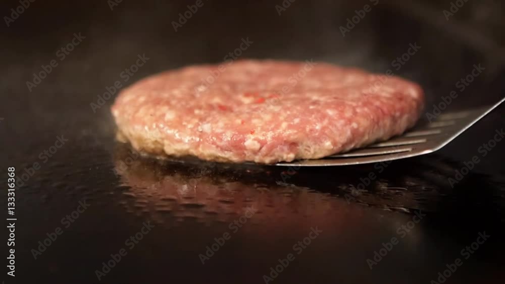 Flipping fresh burger on a grill. Flipping fresh burger on a grill.