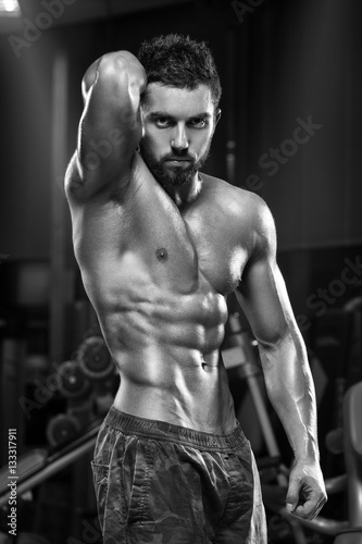Sexy muscular man in gym, shaped abdominal. Strong male naked torso abs, working out