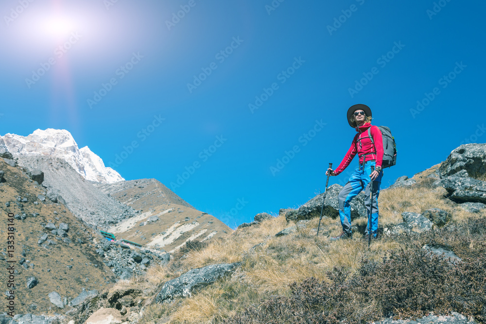 Young Hiker descending on grassy Mountain Slope