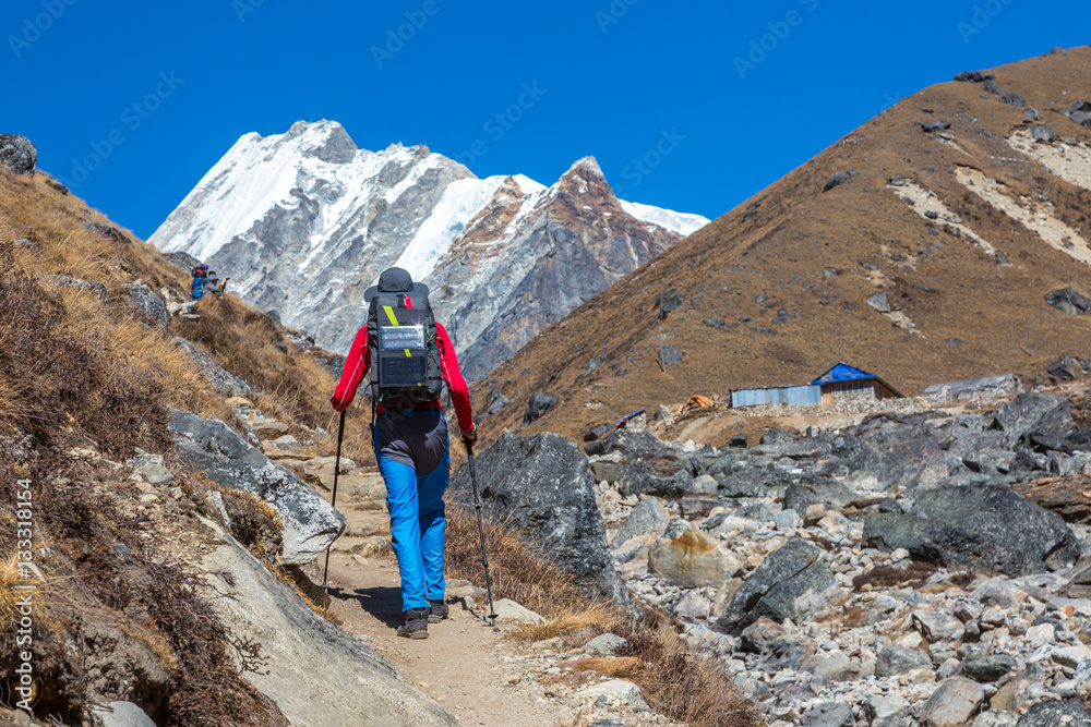 Mountain Hiker walking with Backpack and Solar Battery in Mountains