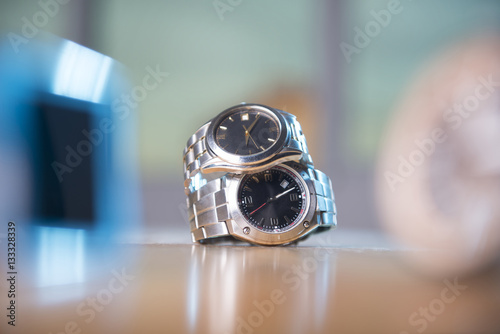 Beautiful stainless steel watches stack one on top of other focus is on them.