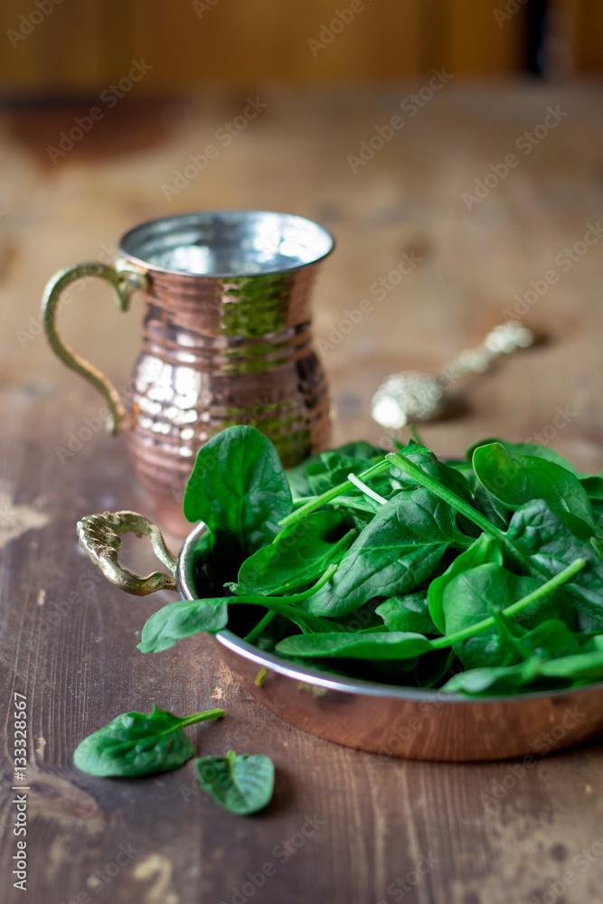 fresh spinach leaves in a beautiful copper bowl