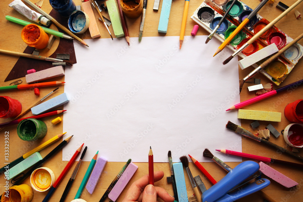 Obraz premium Канцелярские принадлежности и рука человека с карандашом 