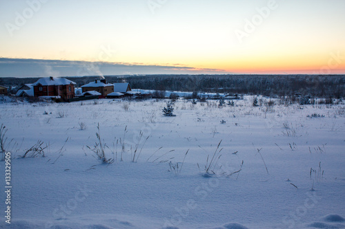 rustic cabins nestled in snow on a cold winter evening