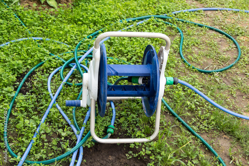 tangled garden hose with a reel on grass