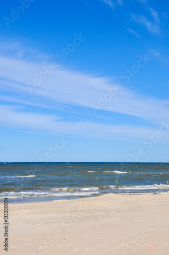 Deserted beach in Palanga Lithuania. Yellow sand on beach near blue sea. Recreation  sea travel  cruise and relax concept
