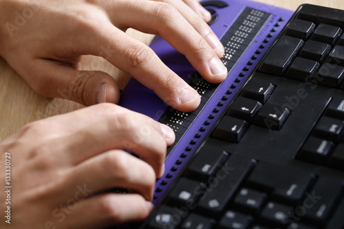 Blind person using computer with braille computer display