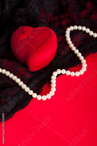 Red gift and white pearl necklace on black lace underwear