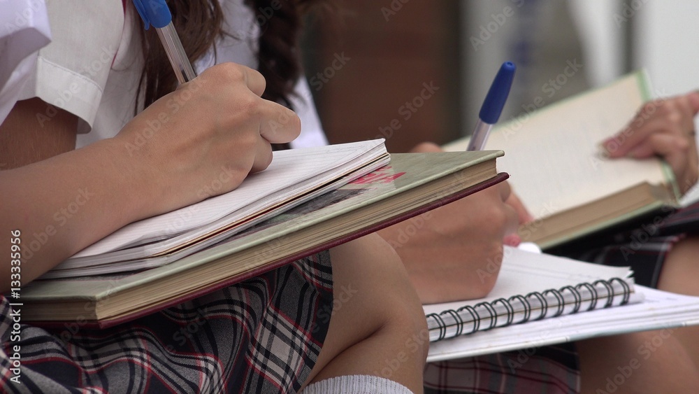 Students Writing In Notepads Students Writing In Notepads