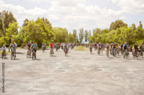 A group of cyclists organized a summer arrival on bikes on the road. The concept of a healthy lifestyle and sports.