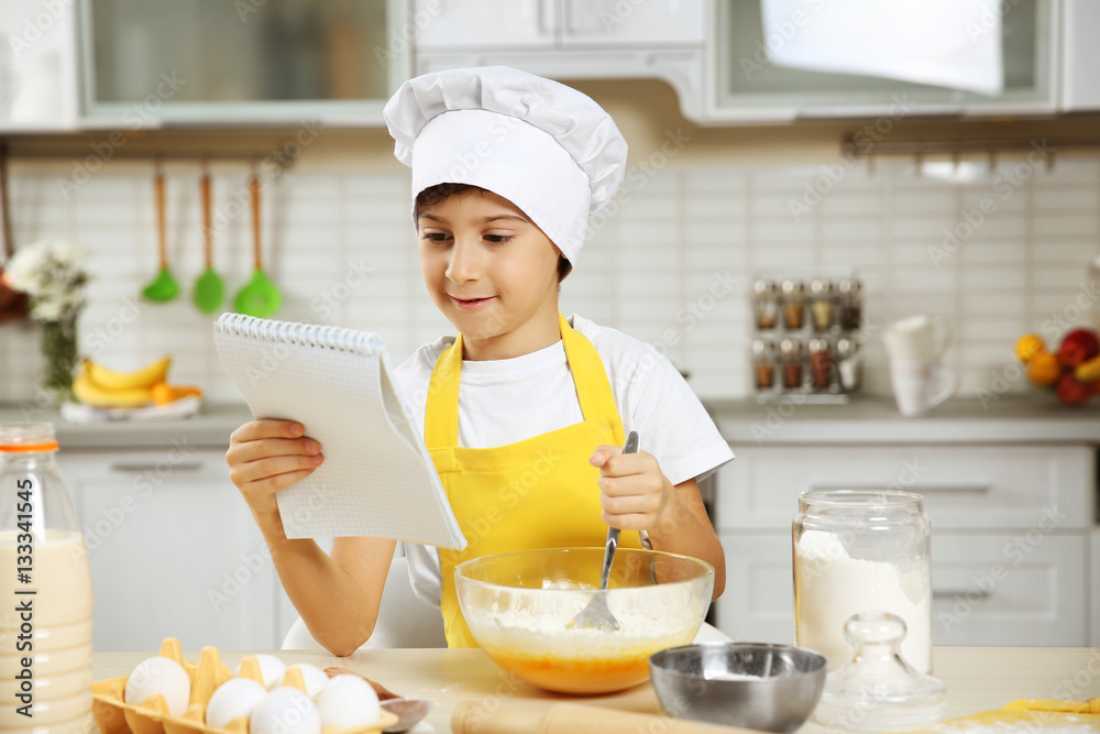 Cute boy cooking in kitchen at home Cute boy cooking in kitchen at home