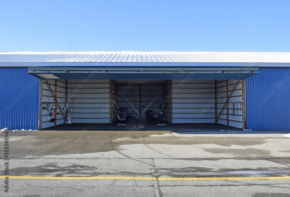 Obraz premium open empty aircraft hangar door lifted up