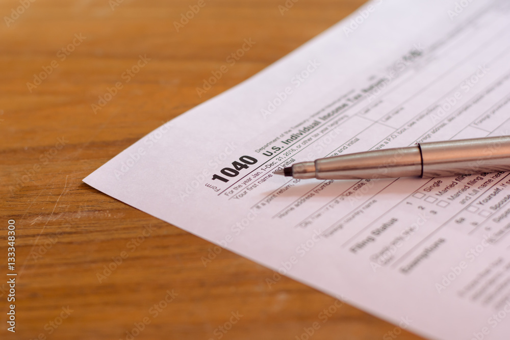 US tax form with pen and calculator selective focus / taxation c US tax form with pen and calculator selective focus / taxation c