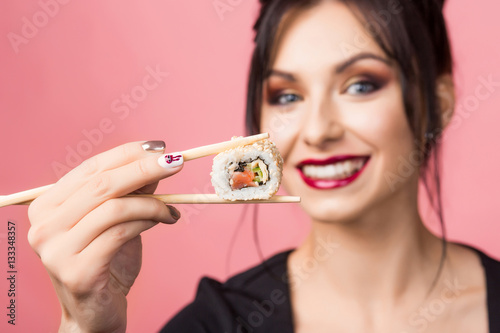 Close-up portrait of a beautiful lady, she eating delicious sushi on sticks and smiling widely, white teeth, perfect face, a healthy Japanese food, makeup, hairstyle, sexy girl, Diet, dieting concept