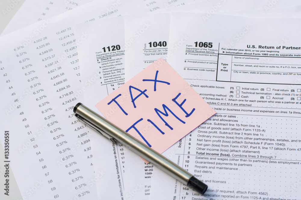 Obraz premium Tax Time written on pink sticker note with on U.S. tax form