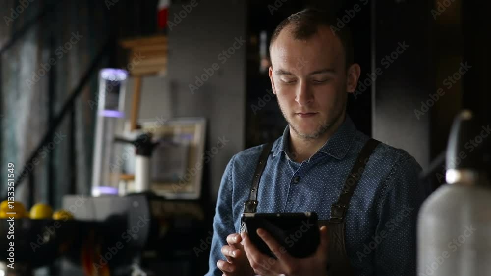 Young bartender exploring new cocktails using tablet Young bartender exploring new cocktails using tablet