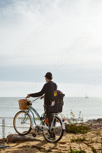 Defocused silhouette of child and father with bike on a beach natural outdoor. Travel vacation background