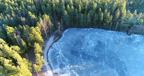 Cinema 4k aerial backward flight over a icy wooden pier, at a icy pond, in Kaskimaa, Raasepori, Finland photo