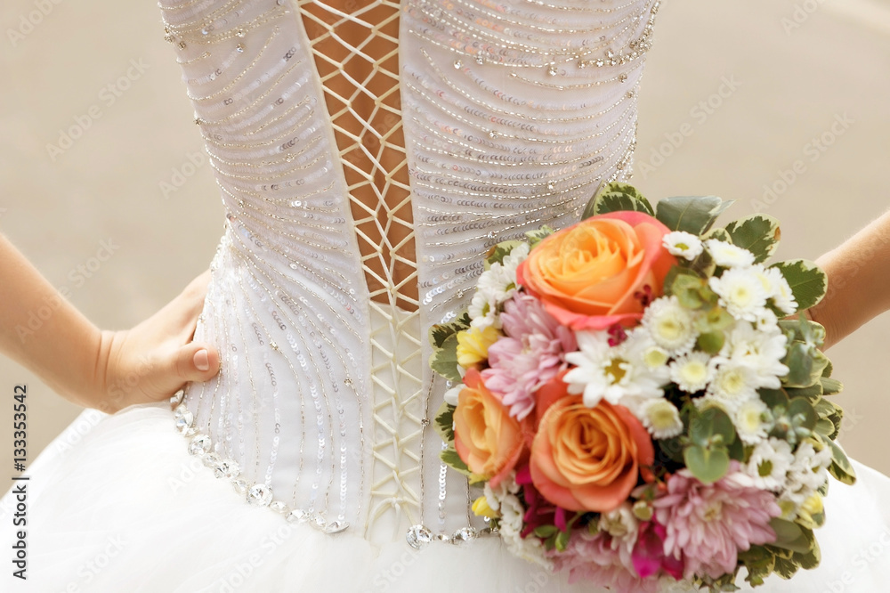 Φωτογραφία white lace corset wedding dress of the bride and the bridal bouquet