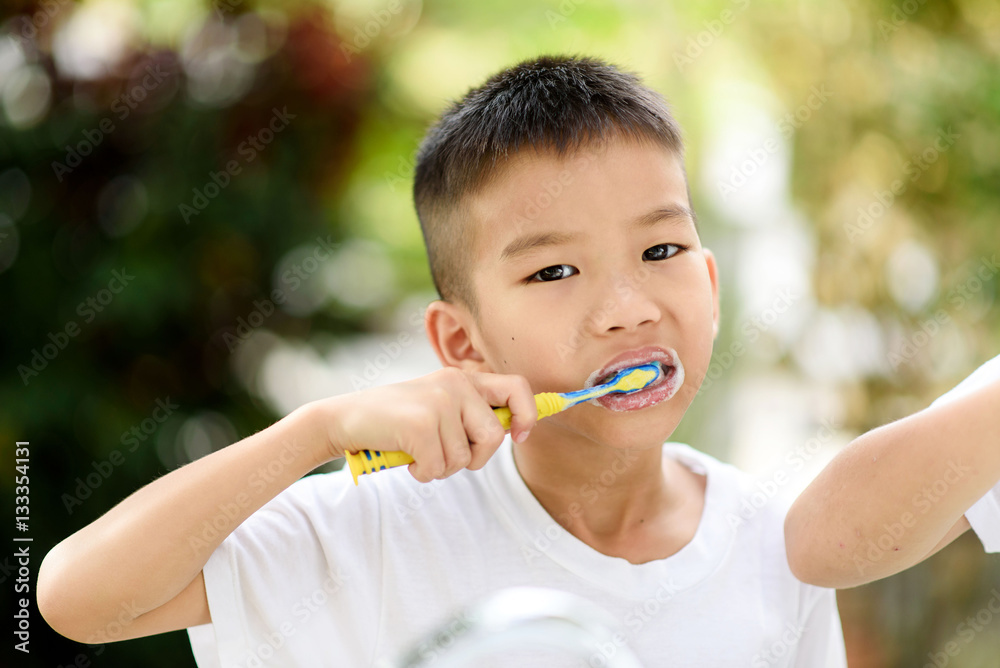 Boy brushing teeth in the garden Boy brushing teeth in the garden