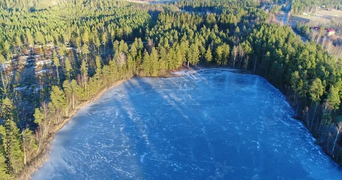 Cinema 4k aerial flight away from a wooden pier and a icy pond, in Kaskimaa, Raasepori, Finland photo