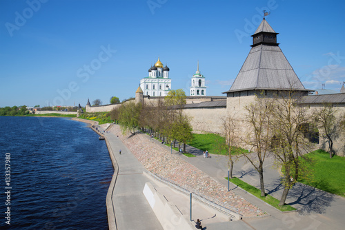 Velikaya river embankment at walls of the Pskov Kremlin in the sunny May afternoon. Pskov, Russia