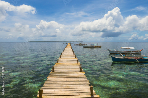 Fototapeta Naklejka Na Ścianę i Meble -  Wooden Island Pier , A Walkway to the Horizon - With Island Tour Boats - Siargao, Philippines