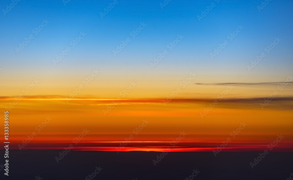 An amazing sunset over earth through a window of a plane, background