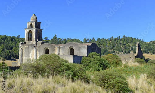 Old abadoned vintage cement church in field near rural village in Mexico, near the volcanoes Orizaba and Iztaccihuatl photo