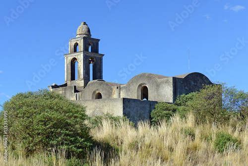 Old abadoned vintage cement church in field near rural village in Mexico, near the volcanoes Orizaba and Iztaccihuatl photo